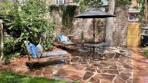 A patio with stone flooring, wicker furniture, and a table with chairs. - "The Cottage" Downtown Denver (Denver)