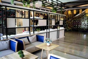 A modern interior with a sofa, a wooden table, and a decorative plant. - City Encounter Boutique Art Hotel (Zhuhai)