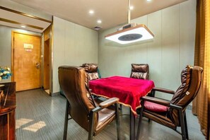 A conference room with a table and four chairs, a door, and a ceiling light fixture. - City Encounter Boutique Art Hotel (Zhuhai)