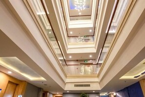 A multi-level atrium with glass railings and a central ventilation system. - City Encounter Boutique Art Hotel (Zhuhai)