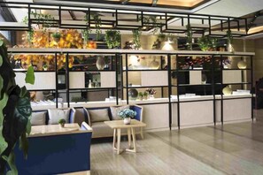 A modern interior with a seating area, a counter, and shelves with plants. - City Encounter Boutique Art Hotel (Zhuhai)