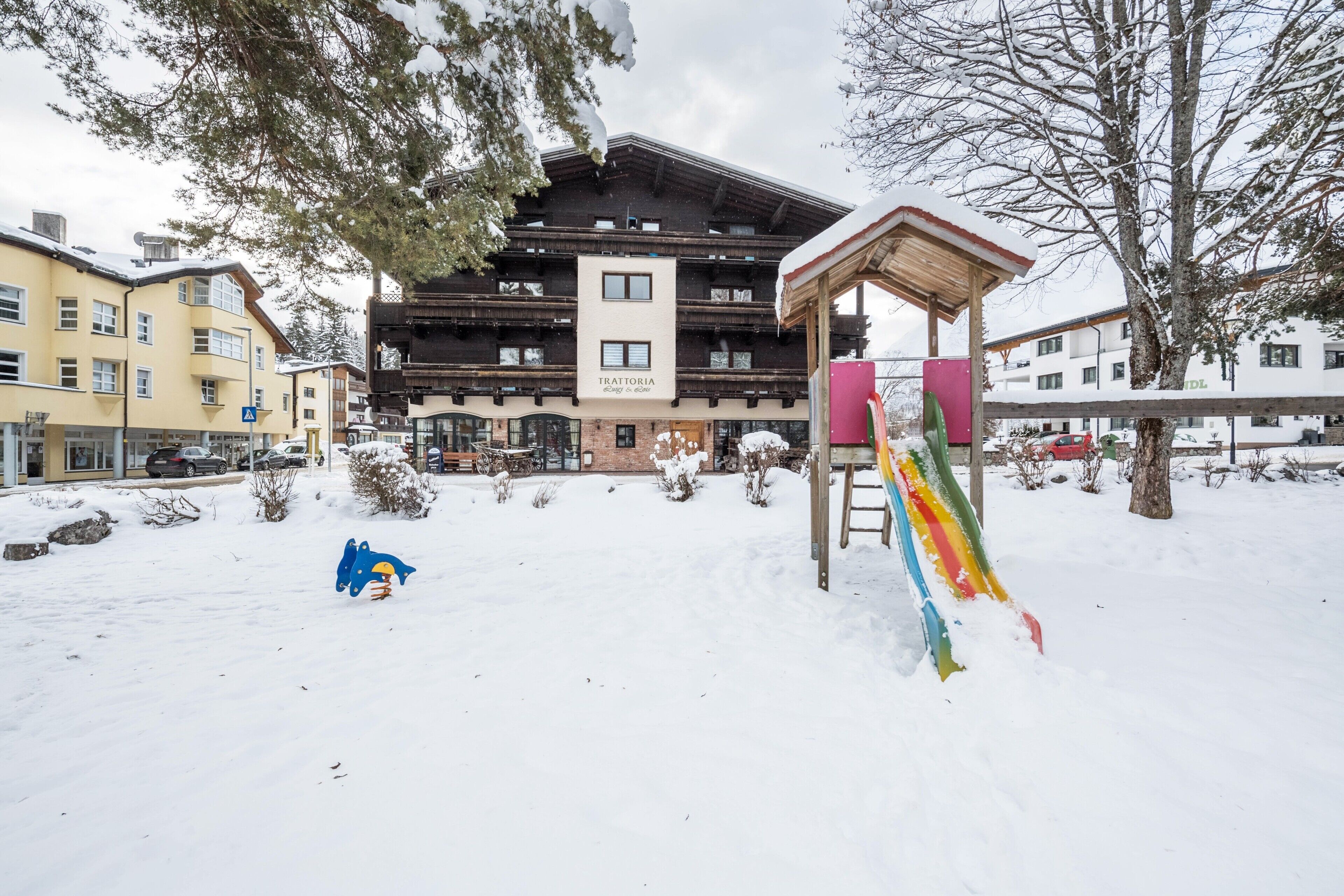 Ein Hotel mit Seilbahn, schneebedecktem Gelände und Gebäuden im Hintergrund.