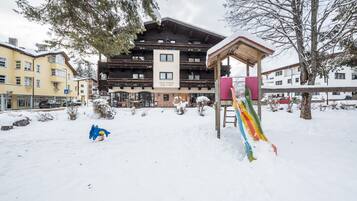 Ein Hotel mit Seilbahn, schneebedecktem Gelände und Gebäuden im Hintergrund.