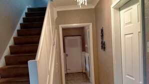 A staircase with carpeted steps leading to a door at the top. - The Nest, an Immaculate 3-Bed House in Walsall (Walsall)