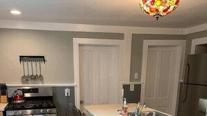 A modern kitchen with a central island, stainless steel appliances, and a wooden floor. - Trip6 Historic Brick Home (Helena)