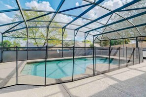 A covered swimming pool with a glass enclosure and a clear view of the surrounding area. - Spacious Getaway ~ Heated LED Pool & Ping Pong (Minneola)