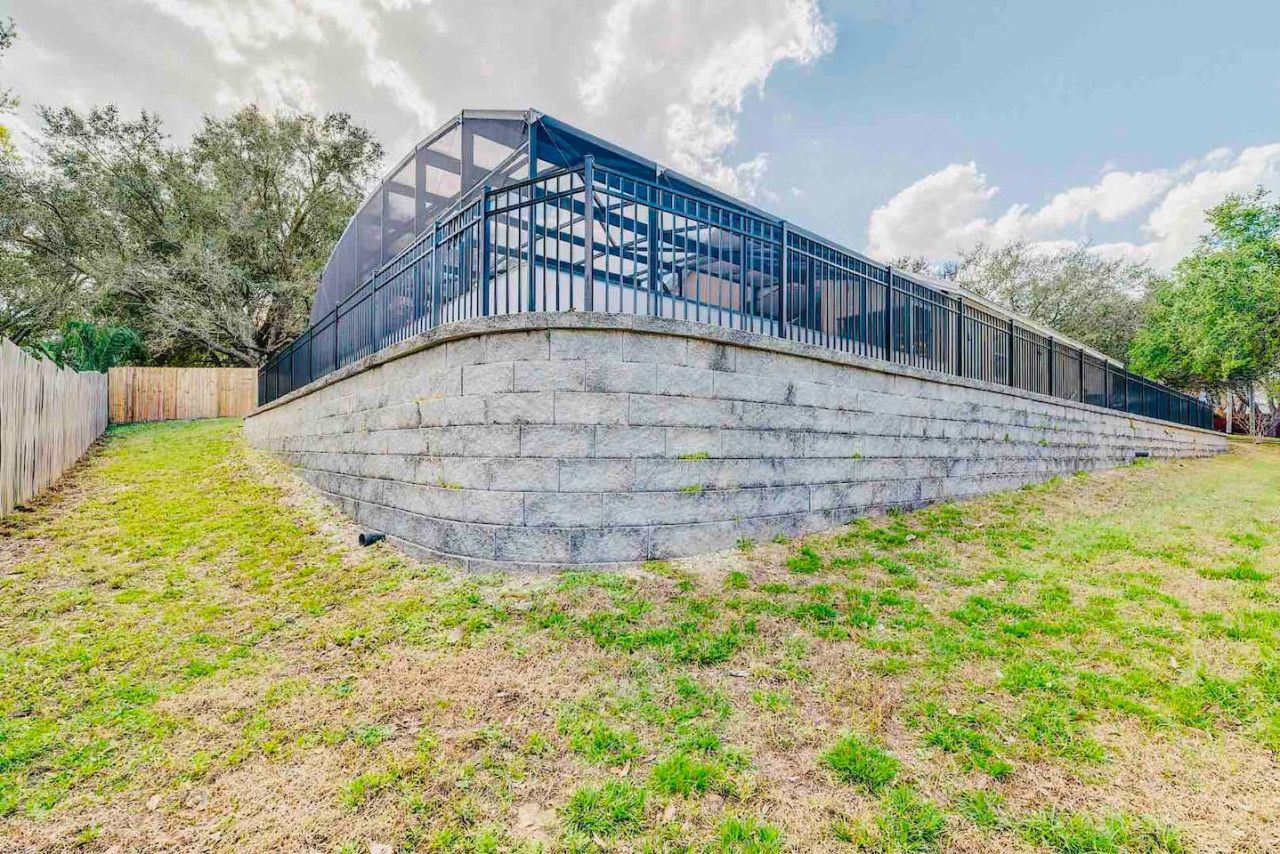 Un bâtiment moderne doté d’une façade en verre et d’un mur de soutènement en pierre.
