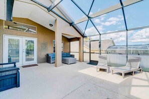 A spacious indoor area with a glass ceiling, seating arrangements, and a view of the outside. - Spacious Getaway ~ Heated LED Pool & Ping Pong (Minneola)