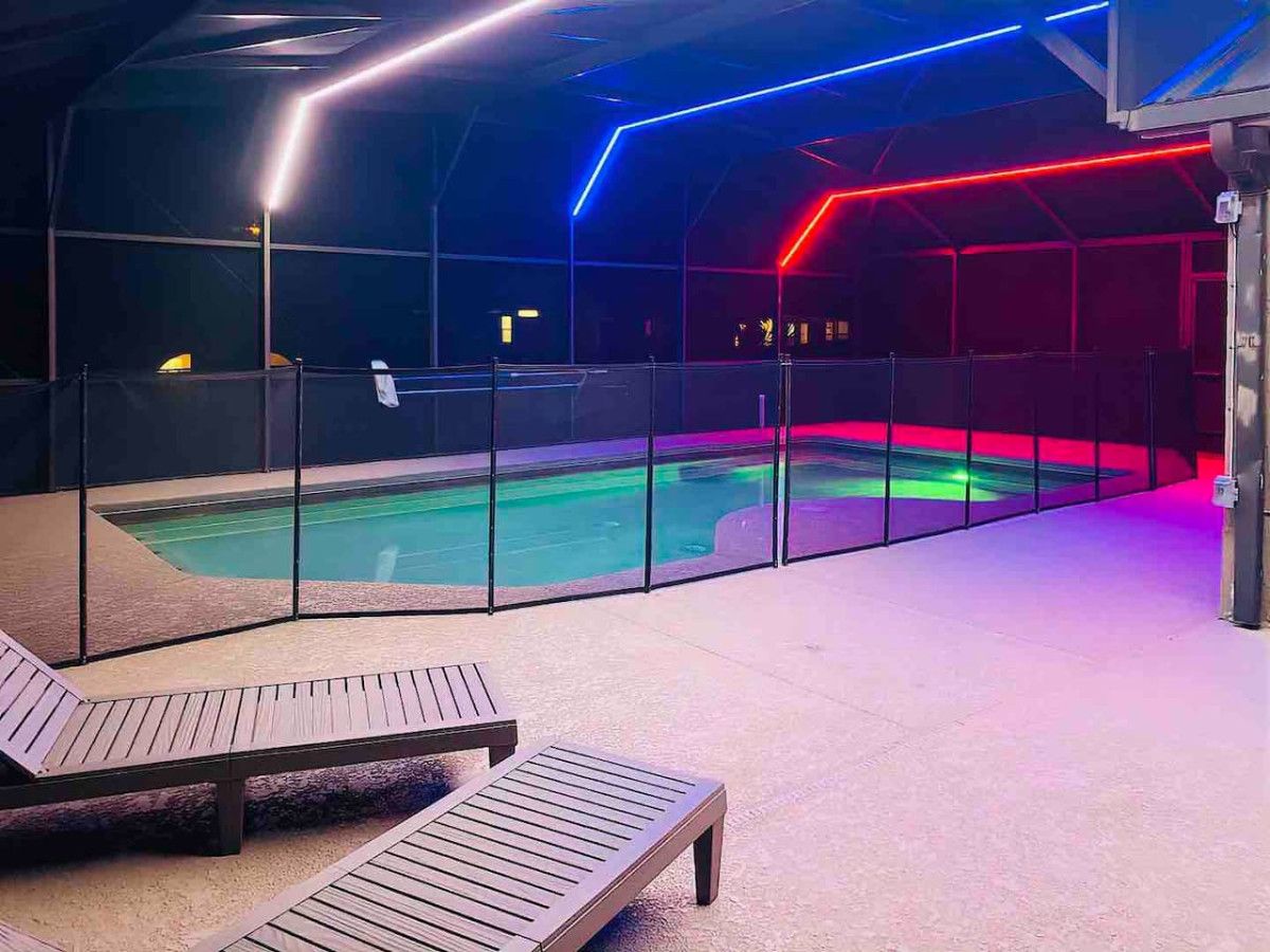 Un área de piscina interior con sillones de descanso y una barrera de cristal.