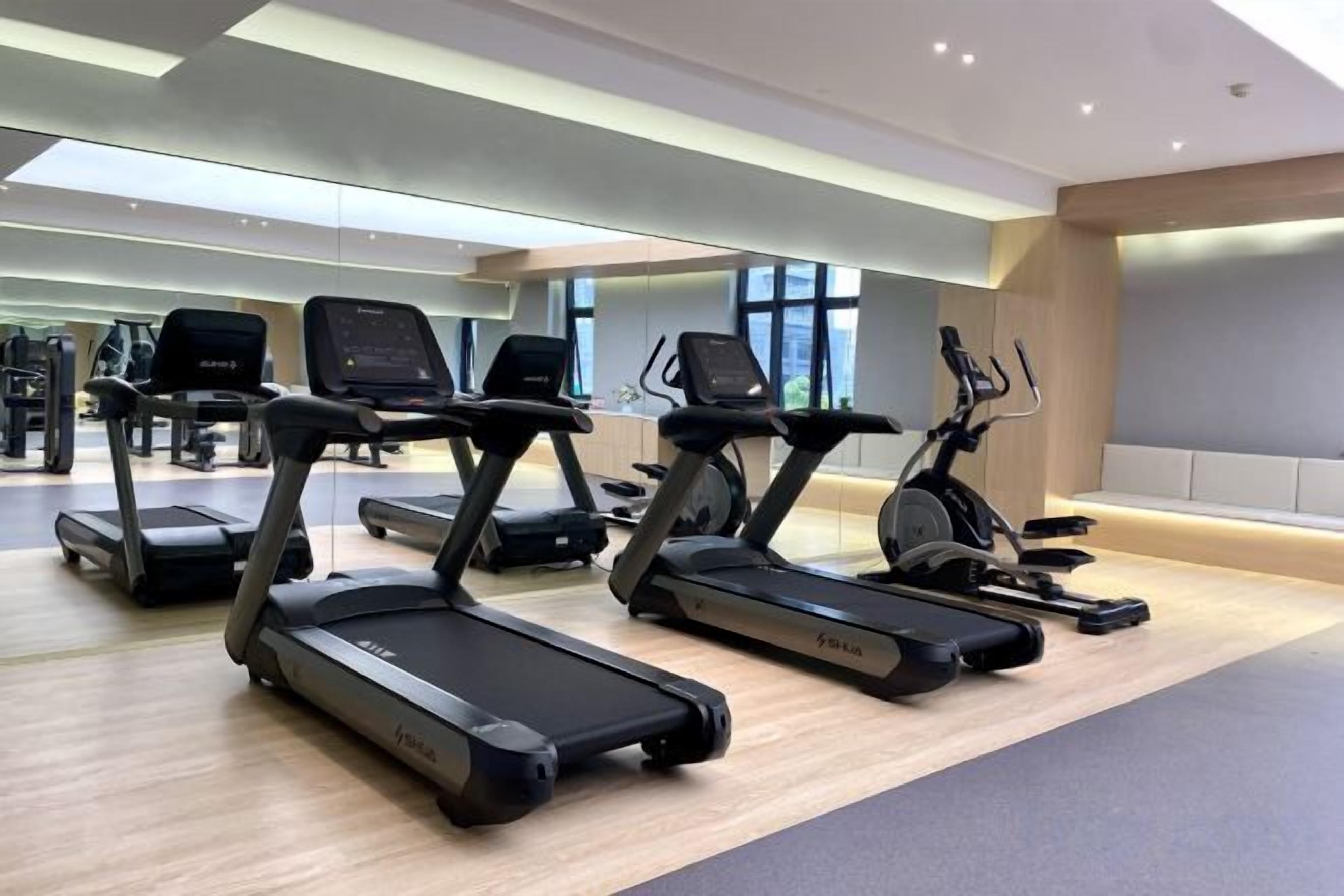 A gym with treadmills, stationary bikes, and other fitness equipment.