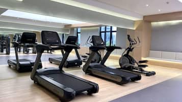 A gym with treadmills, stationary bikes, and other fitness equipment.