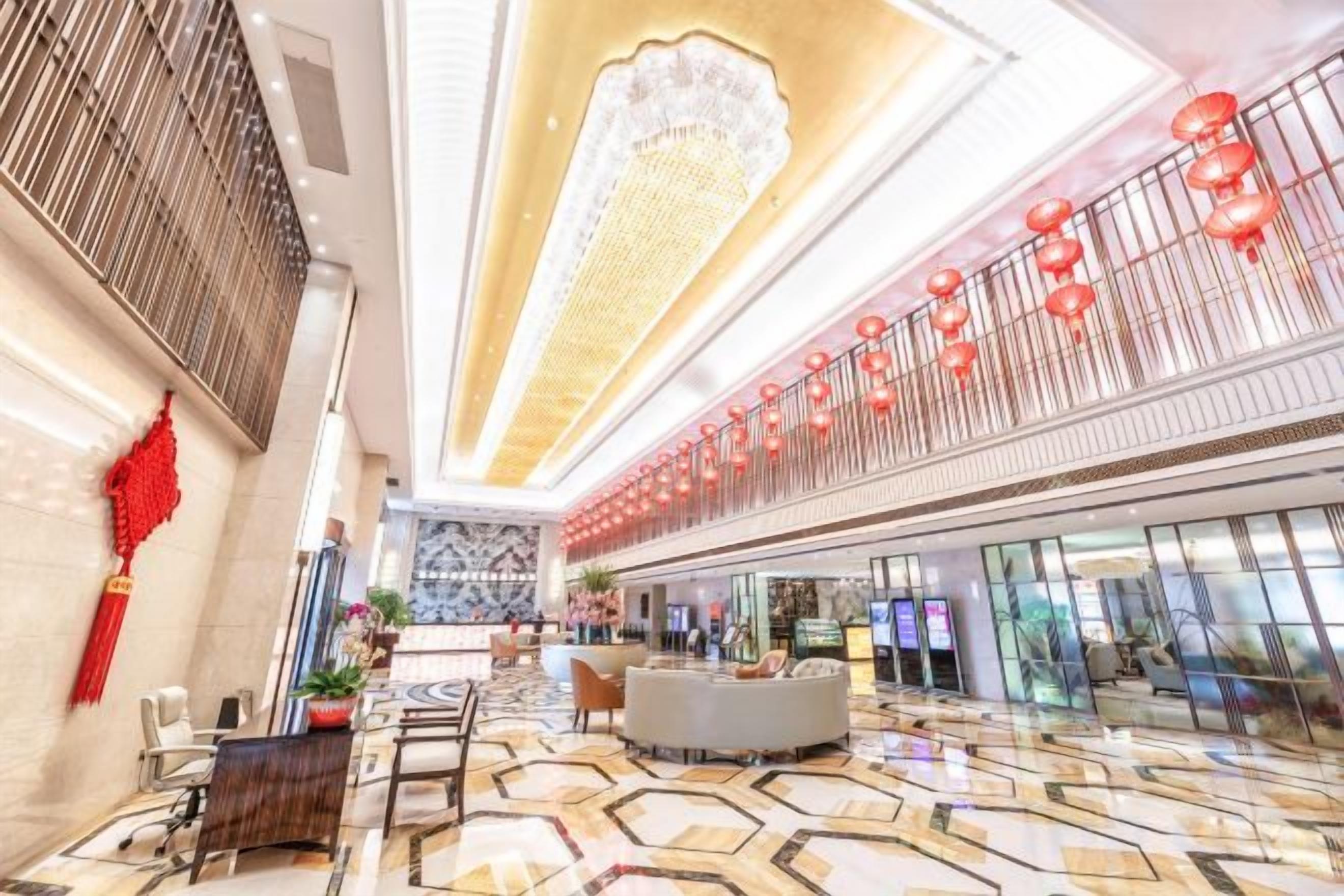 A spacious lobby with a high ceiling, a chandelier, and a seating area.