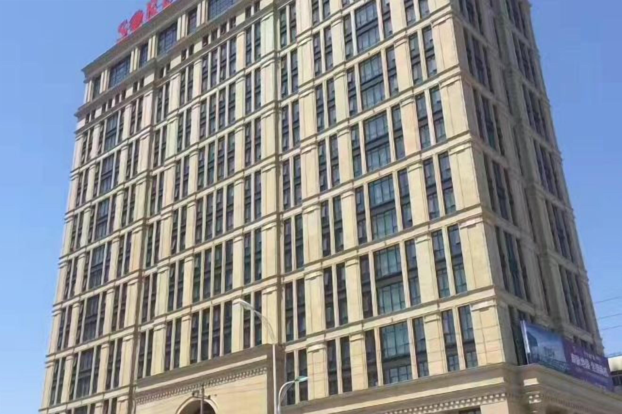 A tall, multi-story building with a symmetrical facade and numerous windows.