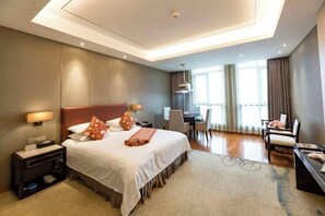 Een hotelkamer met een bed, nachtkastjes, een bureau en een stoel.