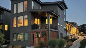 A modern multi-story residential building with a balcony and large windows.