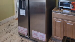 A kitchen with two stainless steel refrigerators, wooden cabinets, a toaster, and a clock on the wall. - Eastbayside/Munjoy - Charming Downtown Escape (Portland)