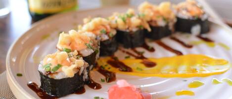 Une assiette de sushis nappés d’une sauce et accompagnée d’une tranche d’œuf.