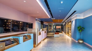 A modern hotel lobby with a reception desk, seating area, and bookshelves. - Hanting Beijing Sanyuanqiao Yansha Embassy Hotel (Beijing)