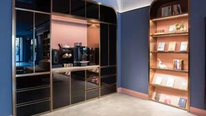 A modern interior with a large black-framed window, a coffee machine, and a bookshelf with books and decorative items. - Hanting Beijing Sanyuanqiao Yansha Embassy Hotel (Beijing)
