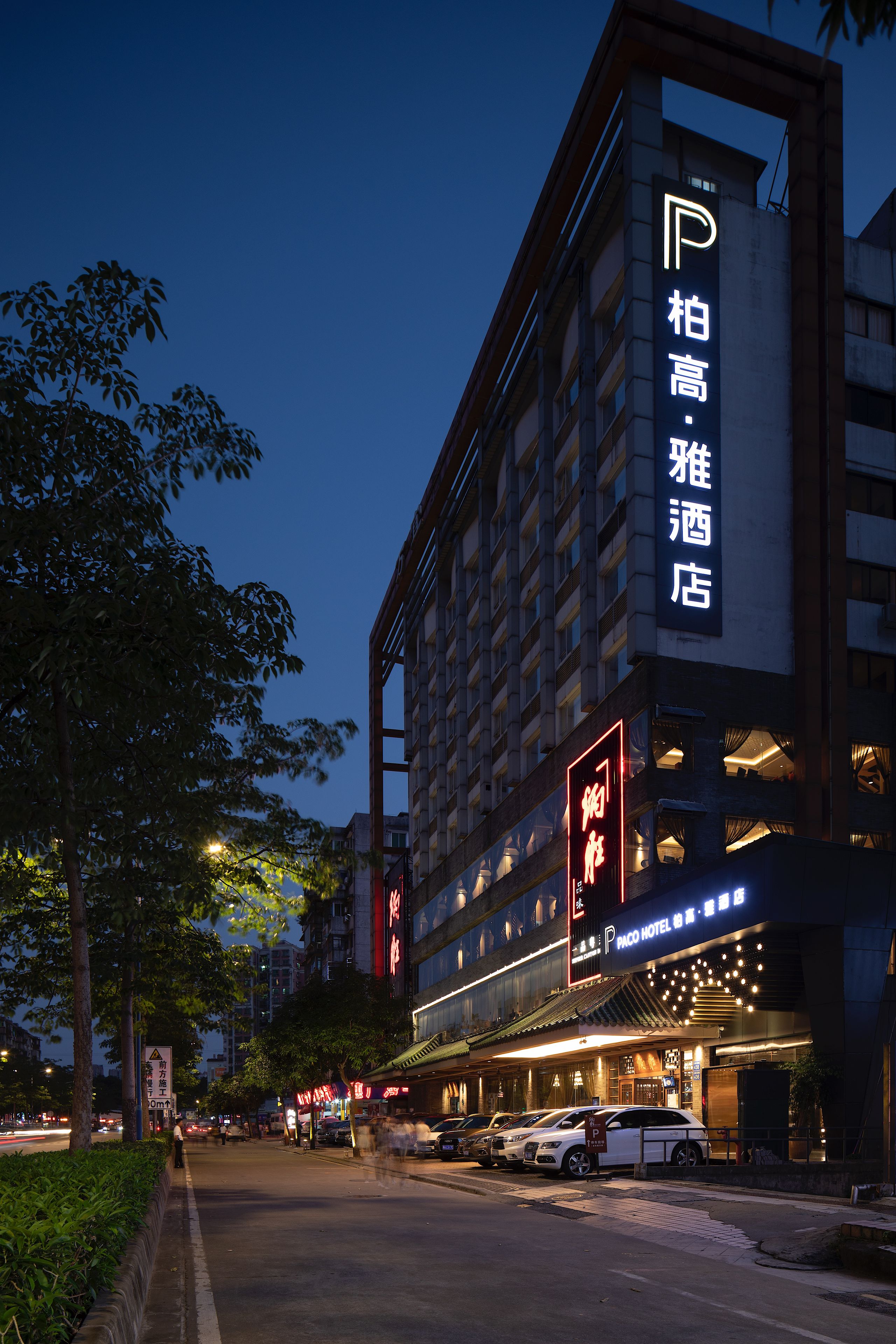 Ein Hotel mit einem gut sichtbaren Schild, auf dem 'Paco Hotel' in englischer Sprache und einer weiteren Sprache steht.