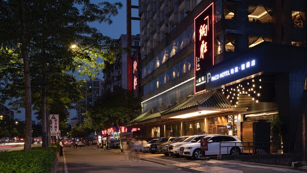 Un hotel con un cartello ben visibile per 'Paco Hotel', con la scritta 'Paco Hotel' in inglese e un'altra lingua.