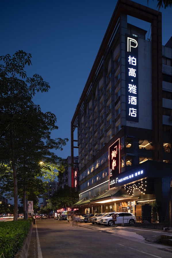 Ein Hotel mit einem gut sichtbaren Schild, auf dem 'Paco Hotel' in englischer Sprache und einer weiteren Sprache steht.