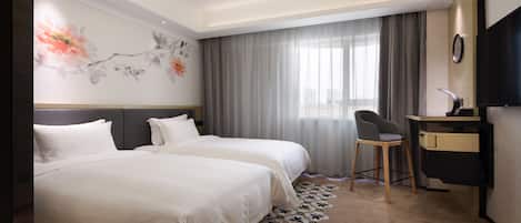 A hotel room with two beds, a desk, a chair, a TV, and a decorative wall.
