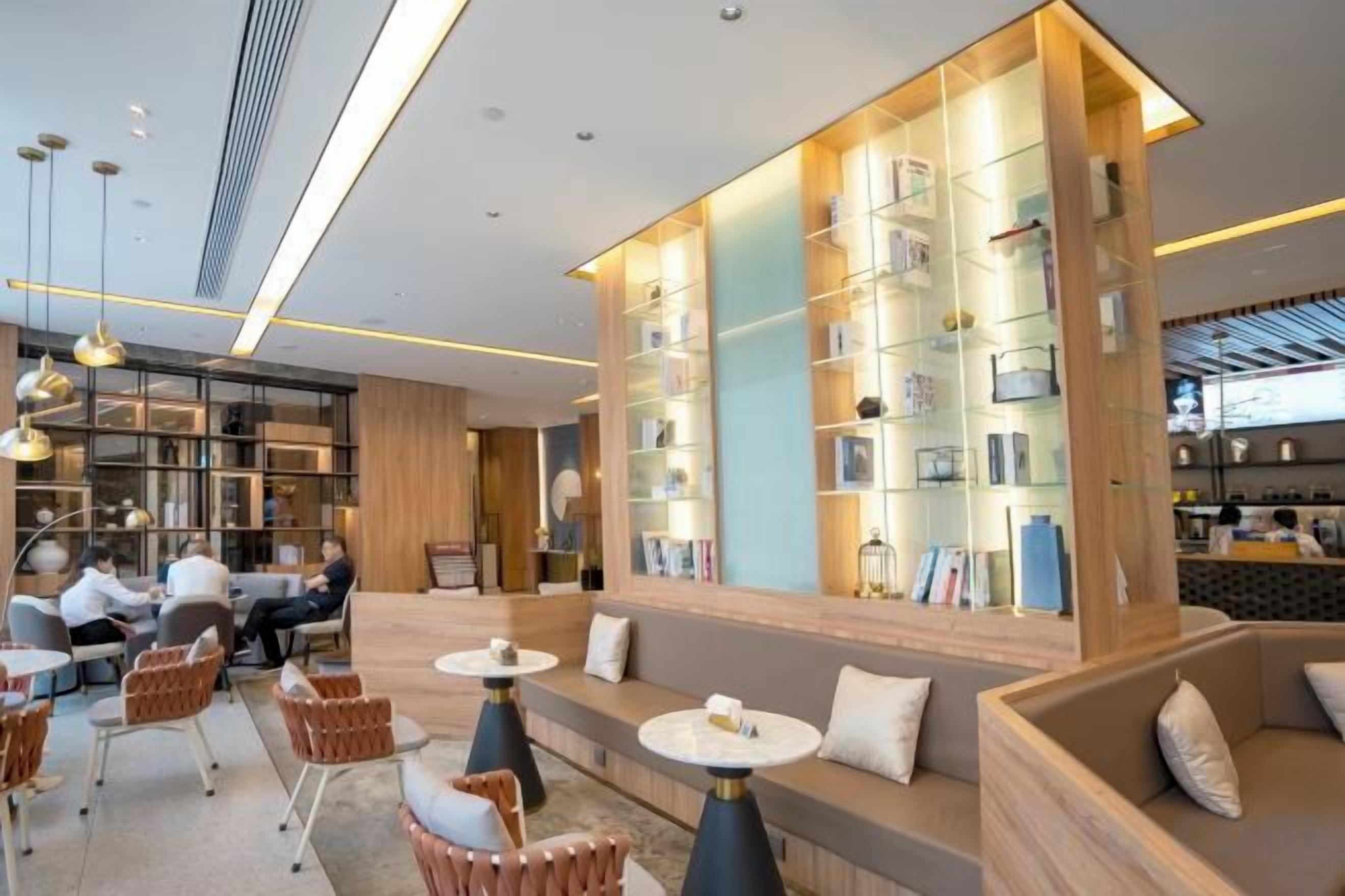 A modern interior with seating areas, a bookshelf, and a bar area.