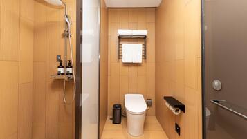 Un baño moderno con ducha, inodoro y un perchero para toallas.
