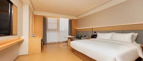 Habitación de hotel moderna con una cama grande, mesitas de noche, un televisor y vistas al exterior.