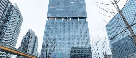 A modern high-rise hotel with a glass facade, multiple floors, and a prominent entrance.