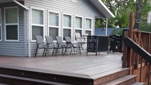 A wooden deck with steps leading up to a house.