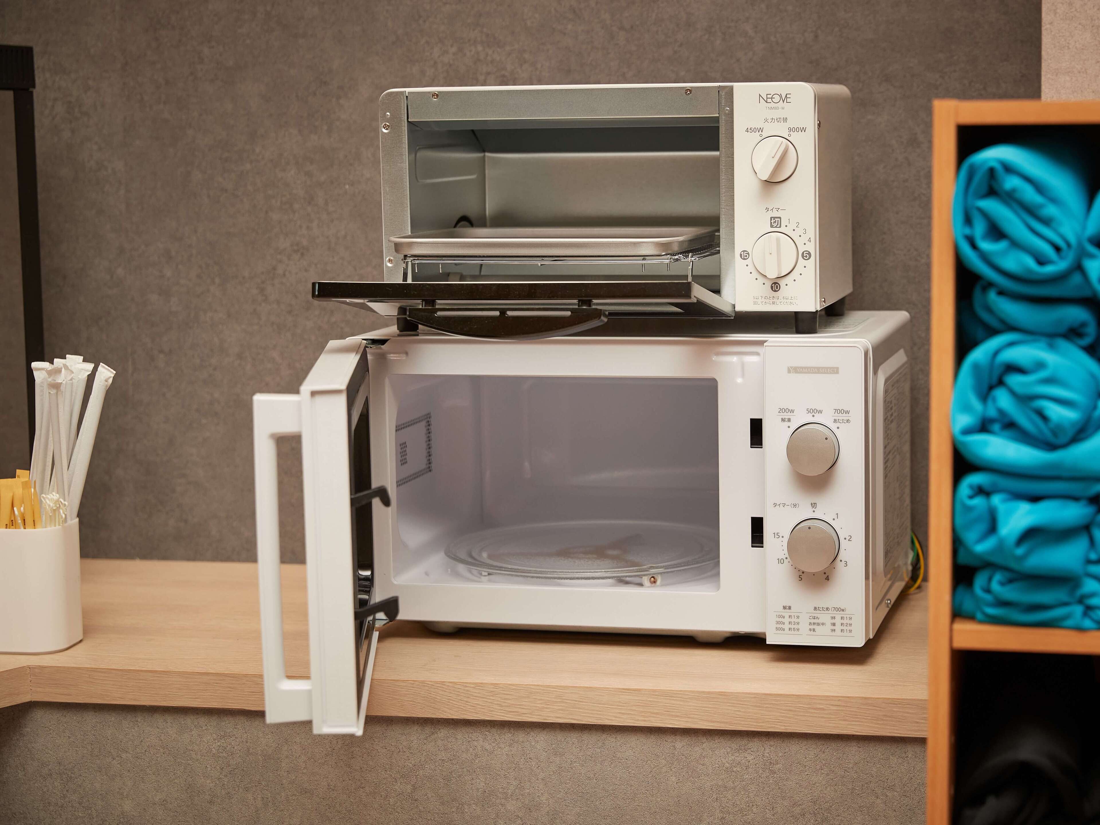 Een compact keukenarrangement met een magnetron en een combioven, boven elkaar gestapeld.