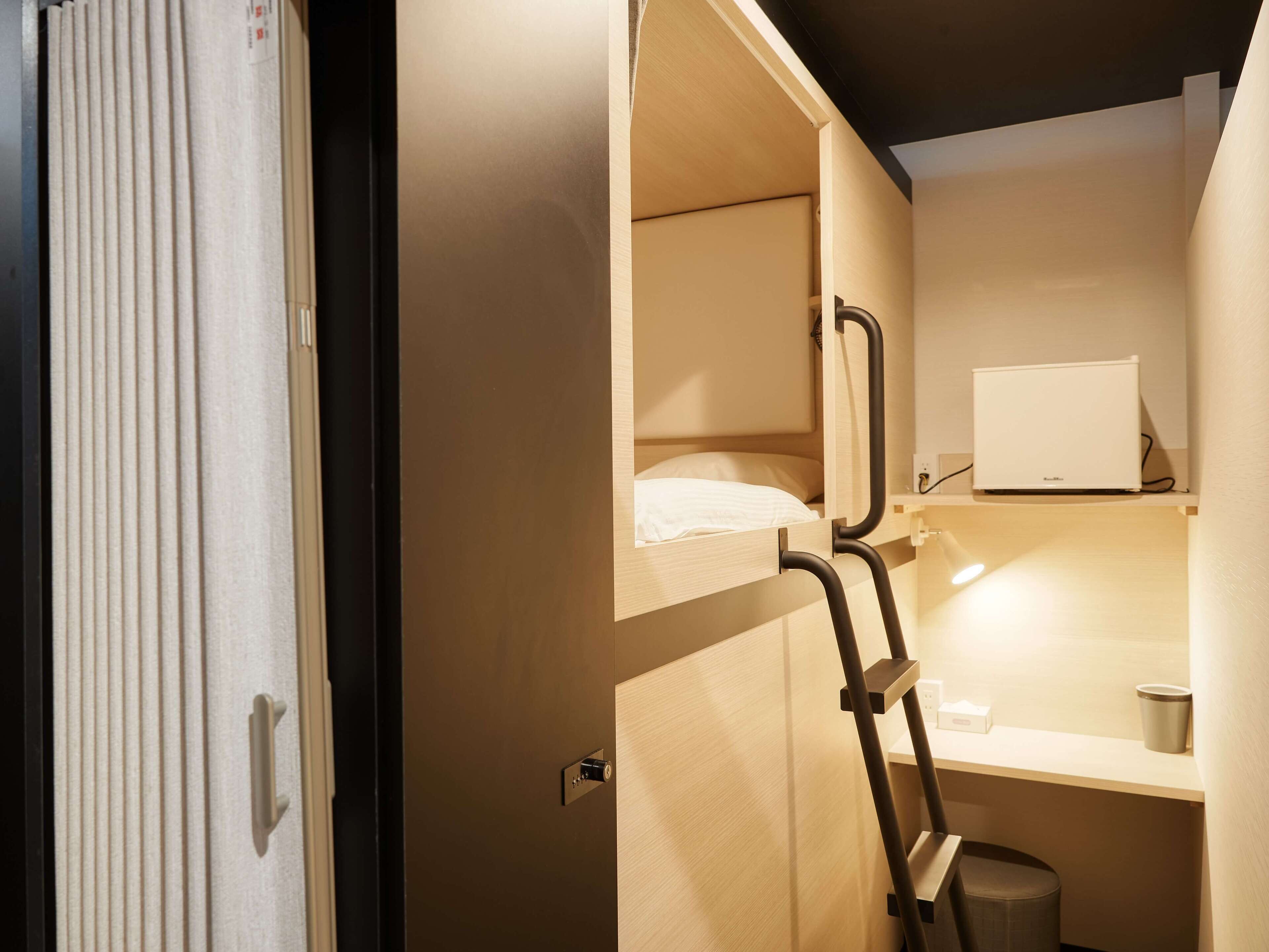 Una habitación pequeña con una cama litera, un escritorio y un espejo.