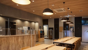 A modern restaurant with wooden tables and pendant lighting. - CABIN&HOTEL CONSTANT NAHA (Naha)
