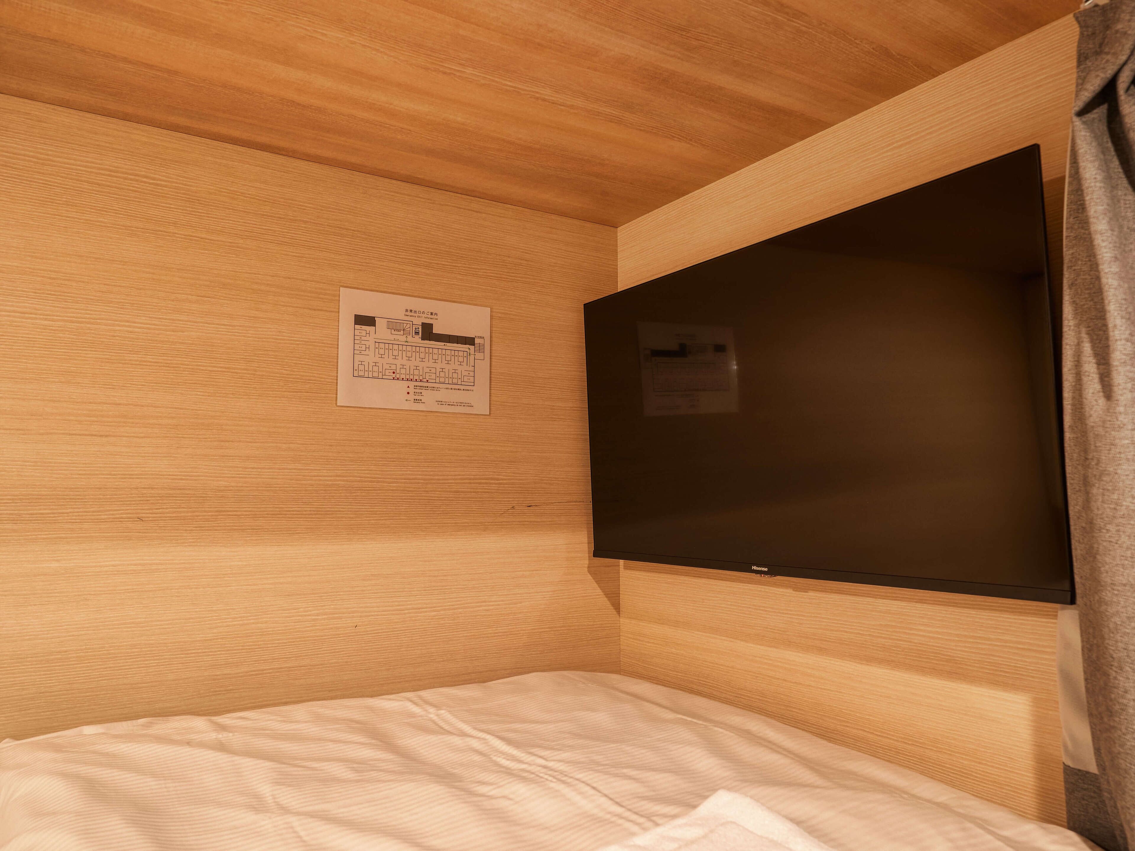 Ein hölzernes Etagenbett mit einem an der Wand befestigten Flachbildfernseher.