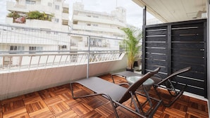 A balcony with a wooden floor, metal railing, and wicker furniture. - CABIN&HOTEL CONSTANT NAHA (Naha)