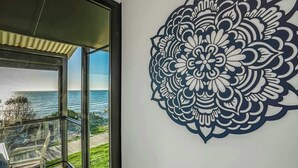 Een kamer met een groot raam met uitzicht op een schilderachtig zeegezicht.