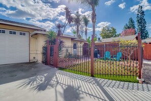 A residential property with a fenced yard, a garage, and a house with a sloped roof.