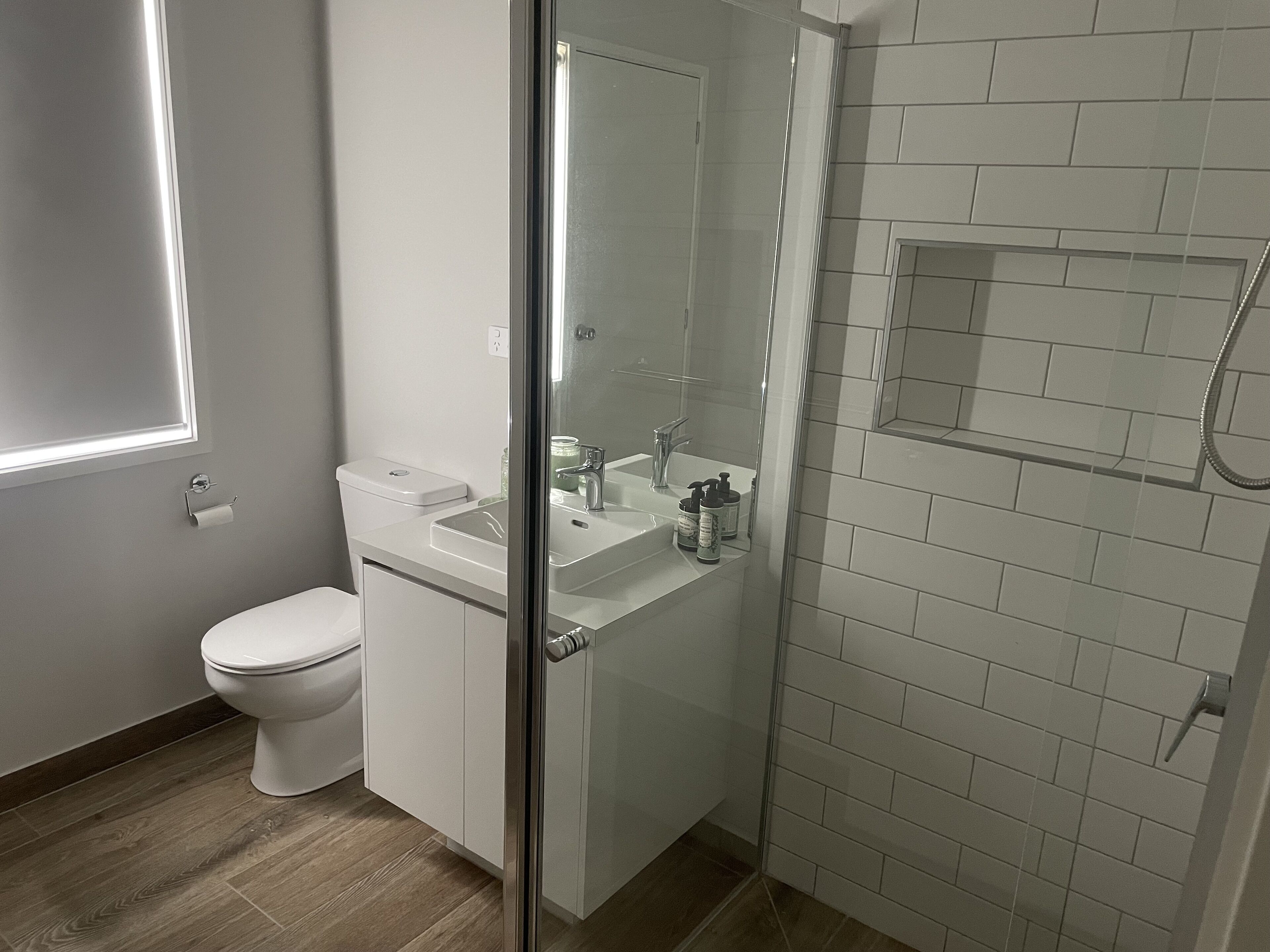 A modern bathroom with a toilet, sink, and shower area.