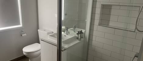 A modern bathroom with a toilet, sink, and shower area.