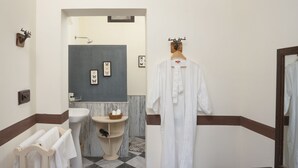 A bathroom with a sink, mirror, and towel rack.