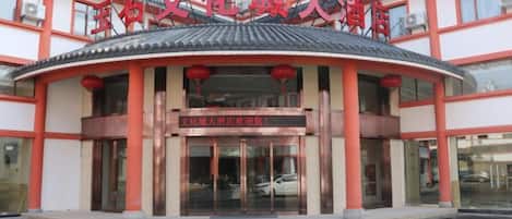 A building with a traditional architectural style, featuring a curved entrance and a prominent sign above the doors.