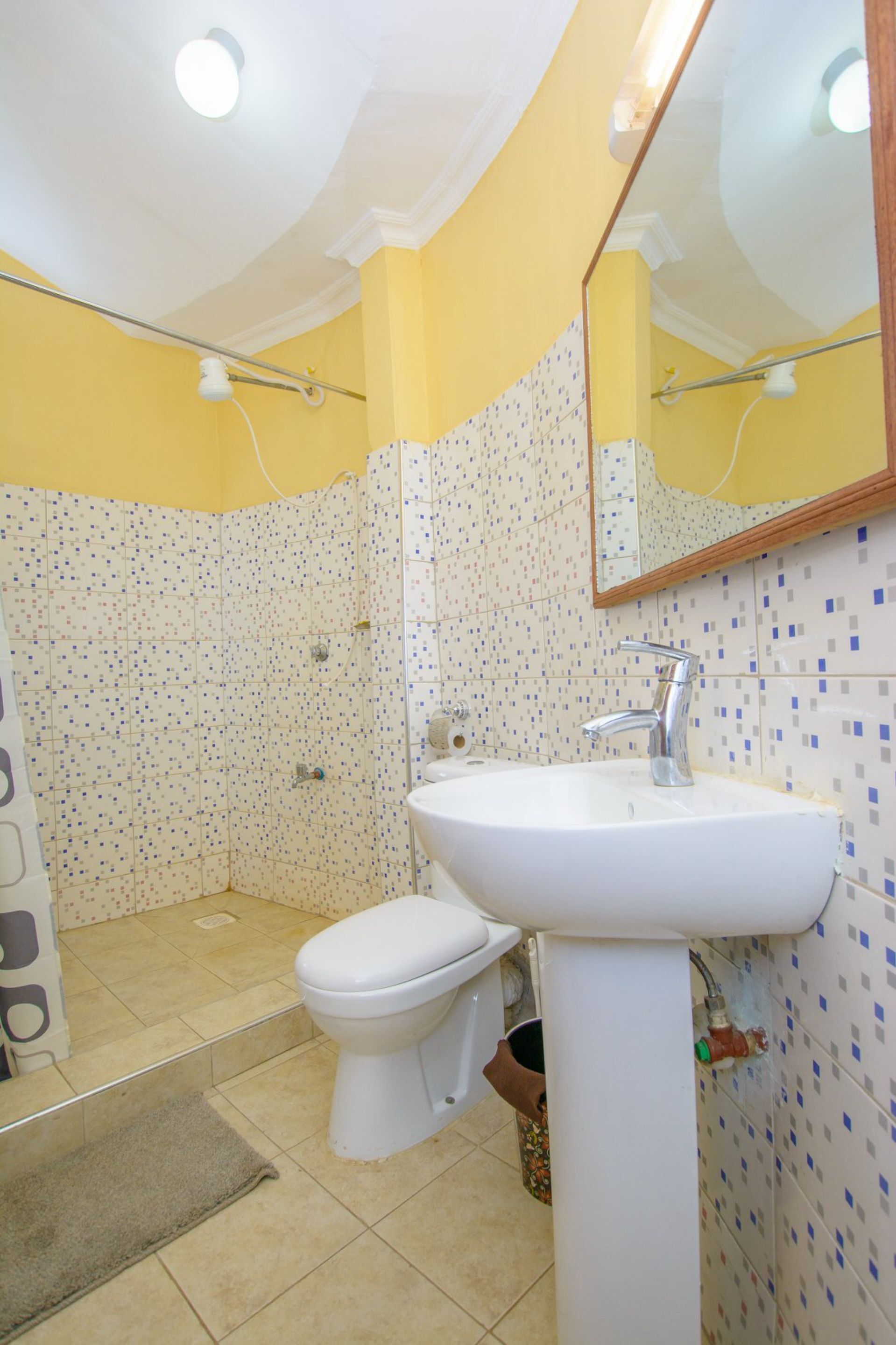 A bathroom with a white sink, a toilet, and a shower area.