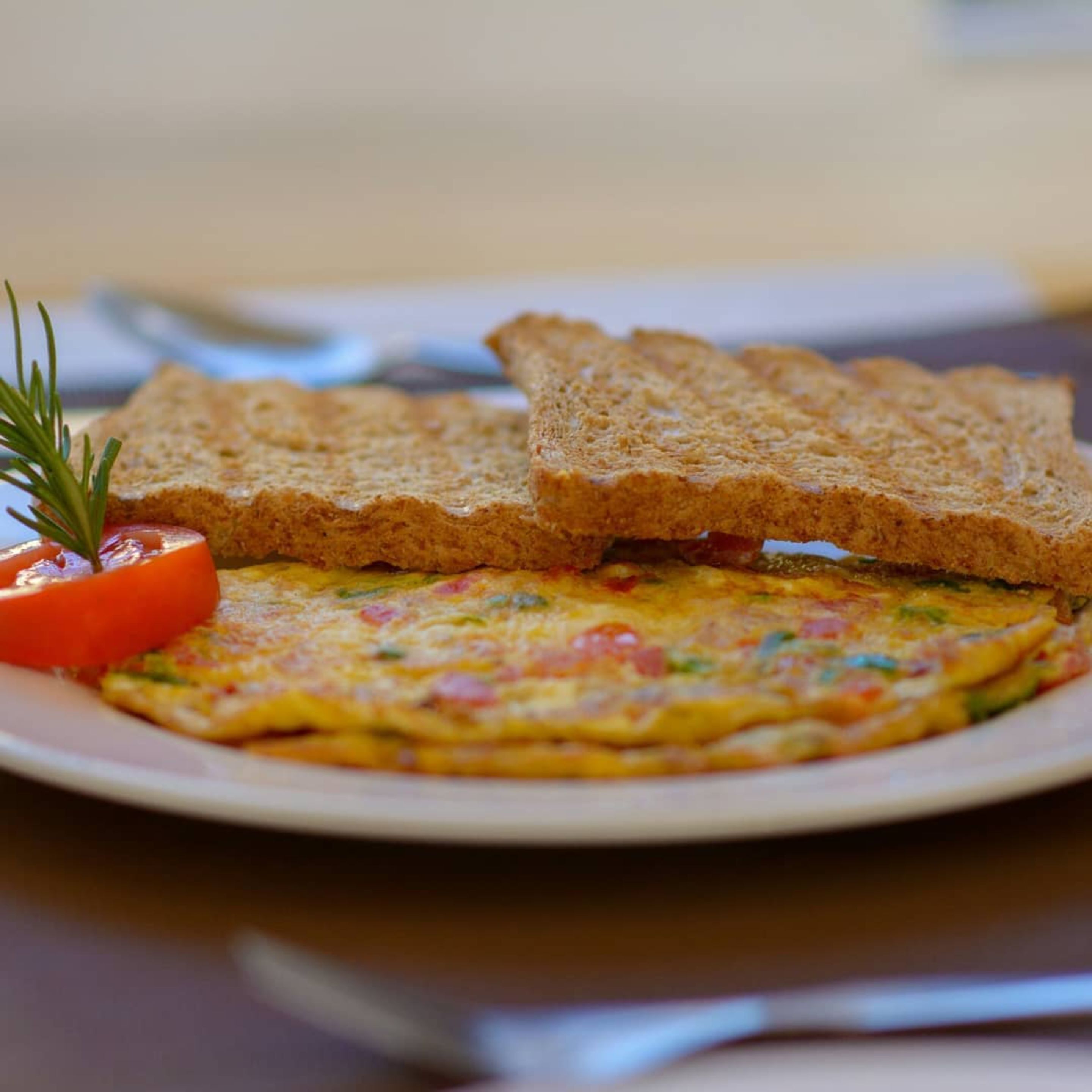 A plate with a slice of toast, a slice of bread, and a piece of toast on a table.