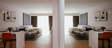 A modern living room with two sofas, a coffee table, and a dining area with a chair and table.