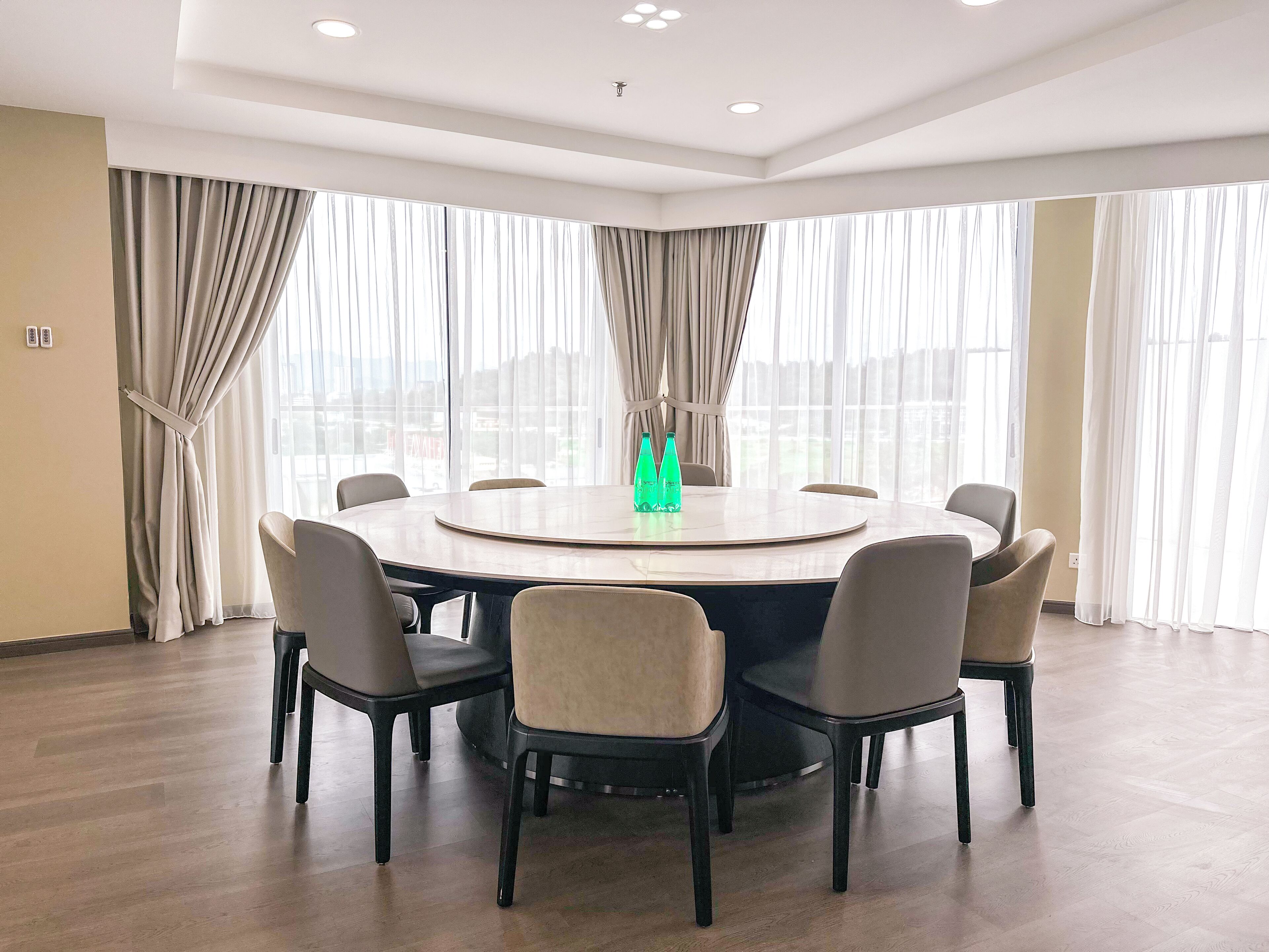 A conference room with a round table, six chairs, and two bottles of water.