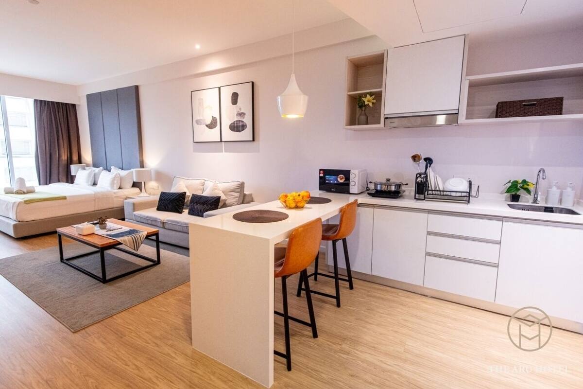 A modern apartment with a living area, a dining space, and a kitchenette.