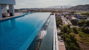 A large swimming pool with a clear view of the surrounding cityscape and distant mountains. - The Aru Hotel, Aru Suites by Ayuhouz (Kota Kinabalu)