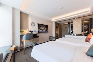 A modern hotel room with a large bed, a desk with a chair, a television, and a bathroom visible through an open door. - Paco Hotel (Guangzhou)